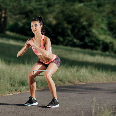 woman squat with resistance flat loop band