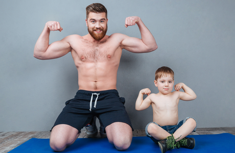 father and young son flexing biceps