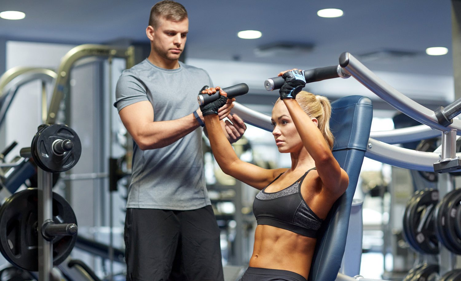 Fit woman working out at gym with trainer