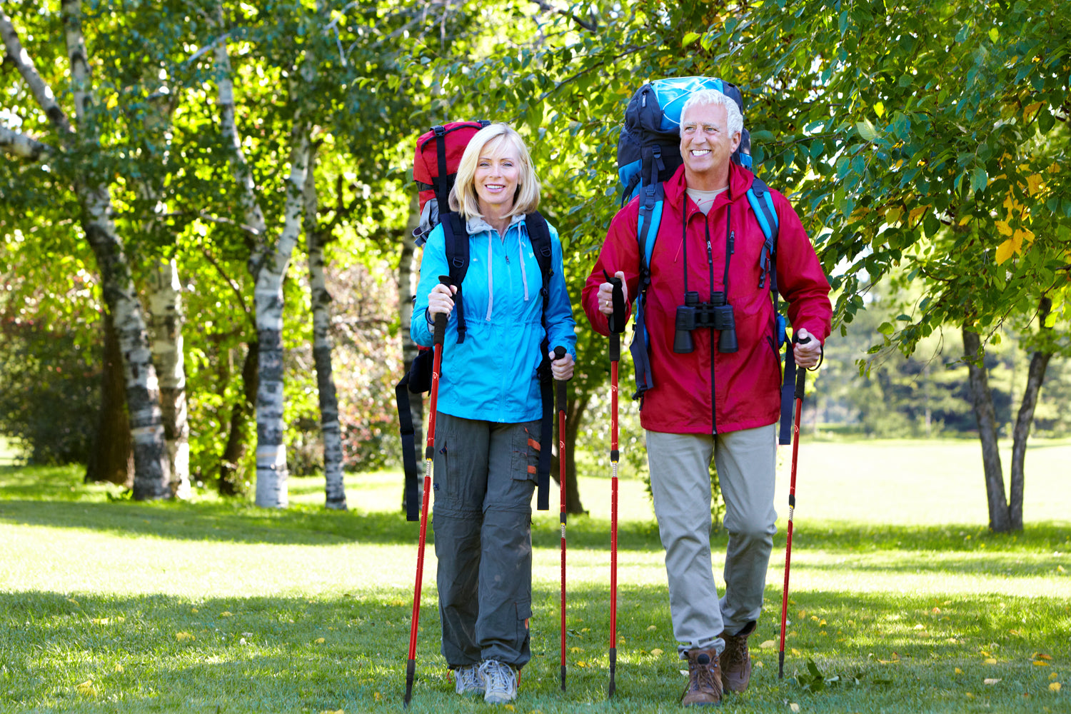 Older couple walking through a park with prosourcefit trekking poles